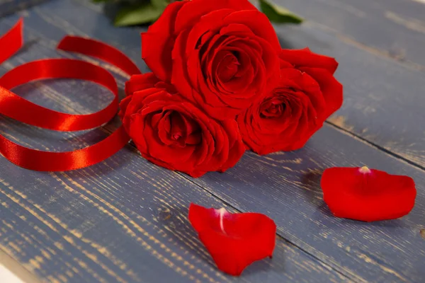 Red roses on a blue wooden background — Stock Photo, Image