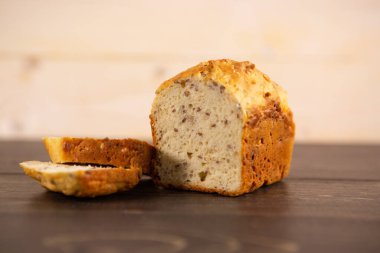 Hafif ahşap arka planda kesilmiş bir somun tahıllı ekmek.