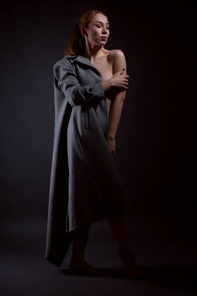 Ritratto di una donna nuda seducente che si toglie il cappotto vestito sul suo corpo nudo — Foto Stock