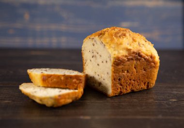 Koyu ahşap bir zeminde taze pişmiş tahıl ekmeği.