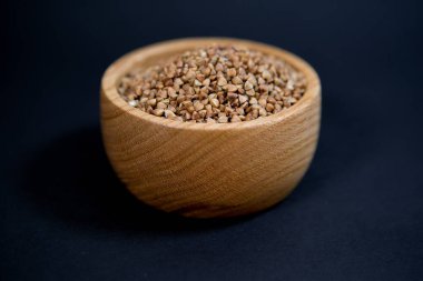 Siyah arka planda güzel bir tahta kupada karabuğday..