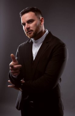 Dost canlısı bir iş adamı parmağıyla seni işaret ediyor. Karanlık bir arkaplanda fotoğraf