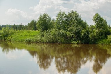 Güzel nehir kıyısı Mavi gökyüzünün altında Cumulus bulutları ile bir yaz günü