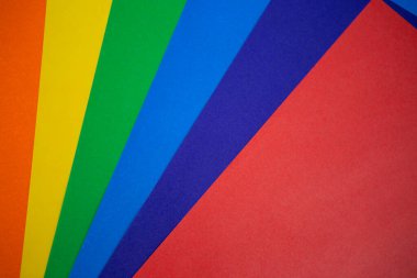 Renkli kağıdın arkaplan dokusu gökkuşağı gibi bir renk spektrumunda yayılır: turuncu, sarı, yeşil, mavi, mavi, sondaki kırmızı tonlarından. Fotoğraf üstten.