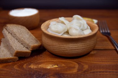 Ev yapımı börekler, Rus börekleri. Tahta bir masada etle doldurulmuş mantı, ravioli..