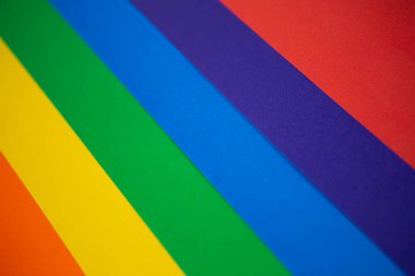 Renkli kağıdın arkaplan dokusu gökkuşağı gibi bir renk spektrumunda yayılır: turuncu, sarı, yeşil, mavi, mavi, sondaki kırmızı tonlarından. Fotoğraf üstten.