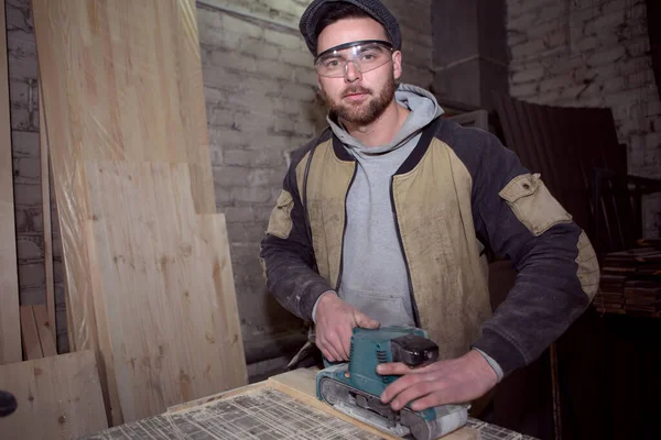 Joiner working with a manual electric sander on the desktop in production — Stock Image Joiner Working Manual Electric Sander Desktop Production Stock Photo