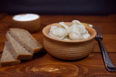 Hamur köfteleri et, ravioli ve soslu ahşap bir masada. Doldurulmuş börek. Rus mutfağı..