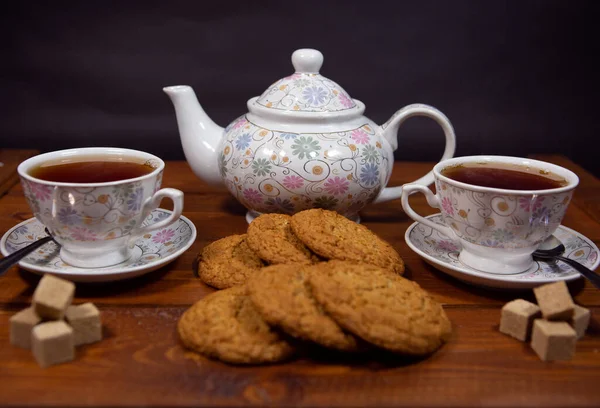 Овсяное овсяное печенье с чашкой чая на деревянном столе. — стоковое фото