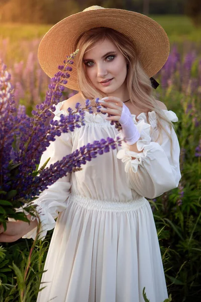 Retro dáma si užívá krásu rozkvetlého lupinového pole. Koncept harmonie. — Stock fotografie