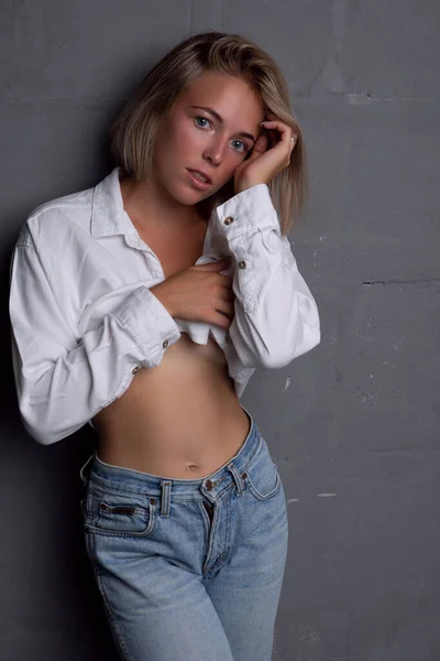 Seksowna młoda kobieta z piękną figurą w dżinsach i rozpiętą koszulą — Zdjęcie stockowe