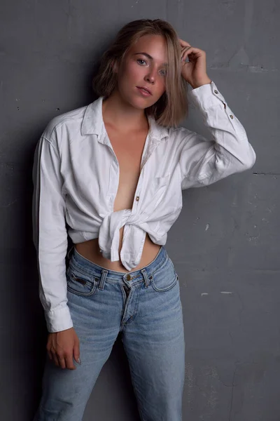 Kot pantolon ve düğmesiz gömlek içinde güzel bir vücudu olan seksi genç kadın. — Stok fotoğraf