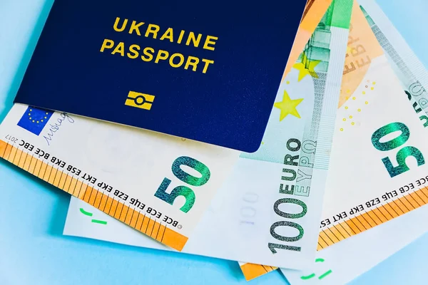 Der ukrainische biometrische Pass ist auf Euro-Scheinen und Dollars in Papierform. Konzept: Gehaltserhöhung, Ukrainer gehen ins Ausland, um in Europa zu arbeiten, Einwanderung zur Arbeit, Urlaub im Ausland, Visum für Europa — Stockbild Der Ukrainische Biometrische Pass Ist Auf Euro Scheinen Und Dollars — Stockfoto
