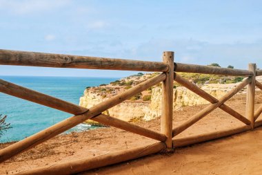 Portekiz 'in Benagil sahilindeki tahta çitler. Açık bir alanda Atlantik Okyanusu manzarası