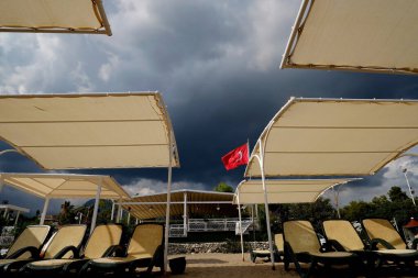 Akdeniz 'de fırtına, sahilde kötü hava güneşli şezlonglar ve Türk tenteleriyle