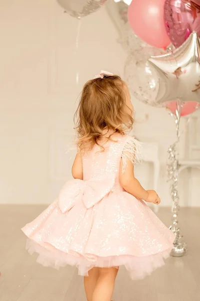Egy Kislány Egy Fényes Szobában Okos Rózsaszín Ruhában Gyermek Léggömbökkel Stock Fotó