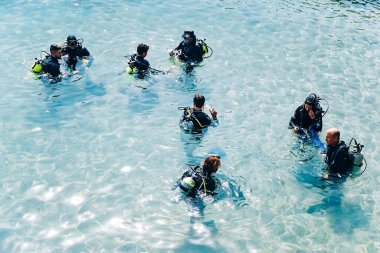 Eilat, İsrail - 01,16,2021: Suda bir grup insan dalış için hazırlanıyor, İsrail 'de kızıl denize dalıyorlar.