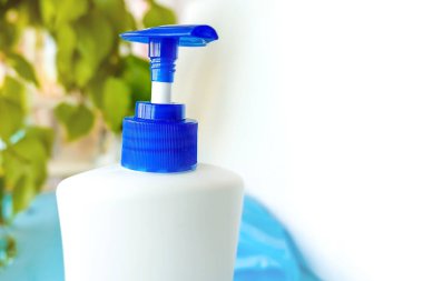 Yeşil çarşaflar ve beyaz bir arka plan, hijyen ürünü ve Covi 'den korunmak için pencerenin yanında duran bir şişe.