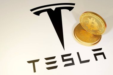 Dnipro, Ukrayna 2021: Tesla logosu yakınında beyaz bir zemin üzerinde üç altın sikke Bitcoi yatırımı