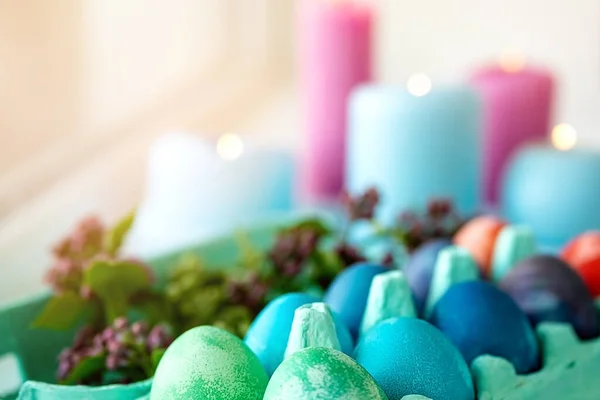 五彩斑斓的鸡蛋放在盘子里 蜡烛在后面燃着 复活节假期表 横向A — 图库照片