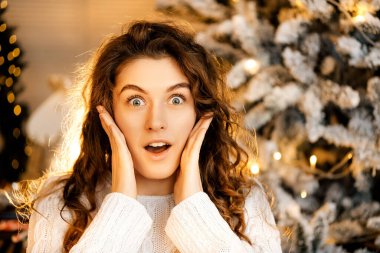 Beyaz kazaklı, siyah saçlı, gülümseyen güzel kıvırcık kız. Mutlu yıllar portresi