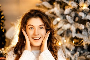 Beyaz kazaklı, siyah saçlı, gülümseyen güzel kıvırcık kız. Mutlu yıllar portresi