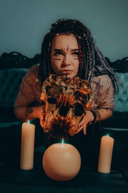 Mavi saçlı kız gece karanlik bir odada, mum yanginda ve inek kafasinda...