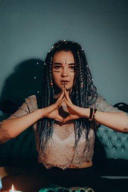 Mavi saçlı kız gece karanlik bir odada, mum yanginda ve inek kafasinda...