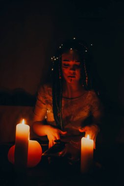 Mavi saçlı kız gece karanlik bir odada, mum yanginda ve inek kafasinda...