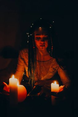 Mavi saçlı kız gece karanlik bir odada, mum yanginda ve inek kafasinda...