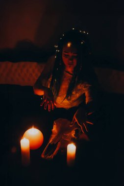 Mavi saçlı kız gece karanlik bir odada, mum yanginda ve inek kafasinda...