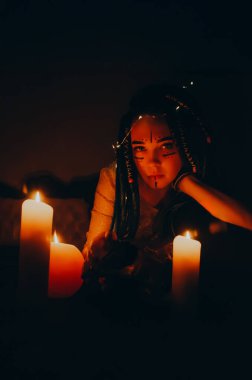 Mavi saçlı kız gece karanlik bir odada, mum yanginda ve inek kafasinda...