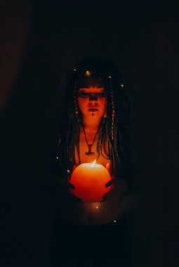 Mavi saçlı kız gece karanlik bir odada, mum yanginda ve inek kafasinda...