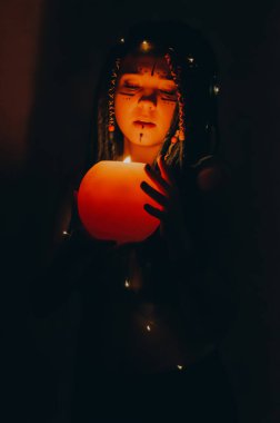 Mavi saçlı kız gece karanlik bir odada, mum yanginda ve inek kafasinda...