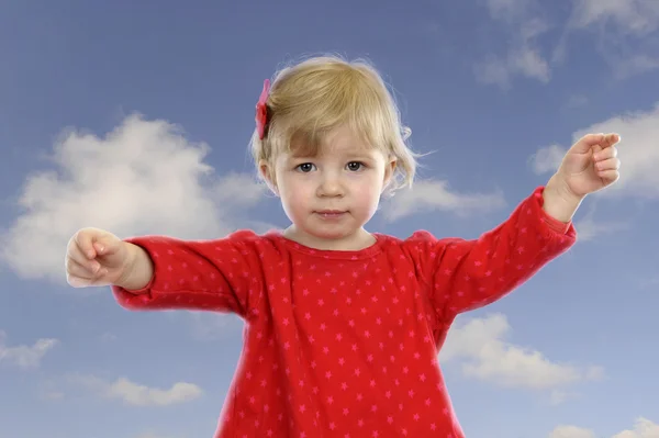 Little toddler girl outdoors against a blue sky with clouds — Stock Photo, Image