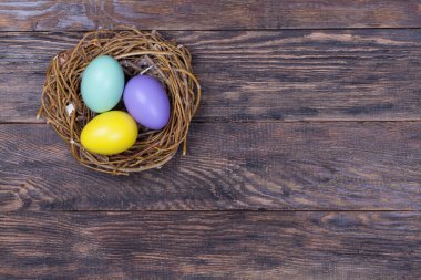 Ahşap arka plan üzerinde renkli yumurta kuş içinde iç içe