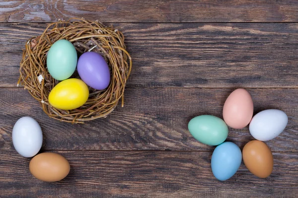 Pasqua uova colorate in nido d'uccello su sfondo di legno — Foto Stock