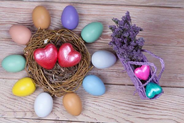 Pasqua uova colorate in nido d'uccello su sfondo di legno — Foto Stock