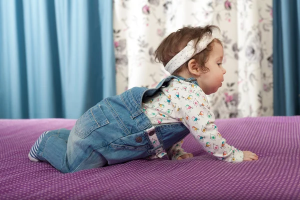 Küçük bebek kız yatağa sürünerek