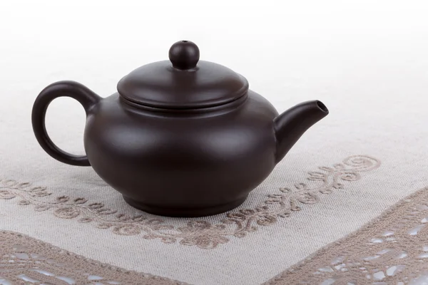 传统的亚洲粘土茶壶配花边桌巾. — 图库照片