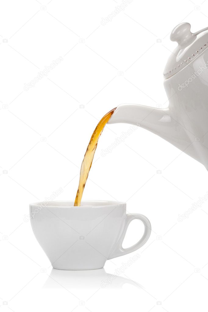 Pouring tea into a cup isolated on white