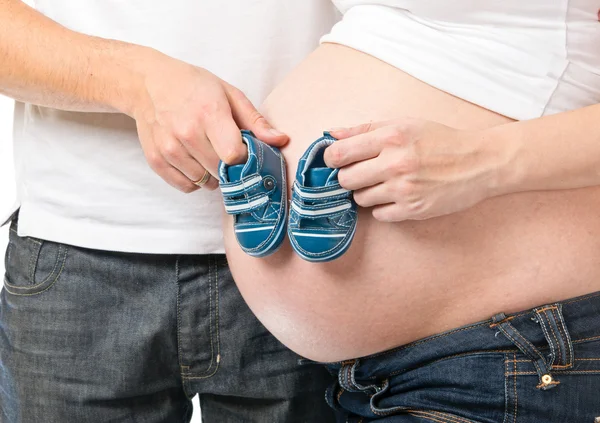 Man and pregnant woman holding small shoes — Stock Photo, Image