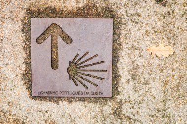 Bir caddedeki metal sembol, Camino de Santiago 'nun Portekiz rotasını gösteriyor..