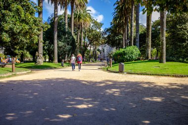 PONTEVEDRA, SPAIN - 7 Ekim 2018: Las Palmeras olarak da bilinen Vicenti Bahçeleri 'nde gezen insanlar, özellikle kamelyalar ve manolyalar olmak üzere çeşitli türlerdeki ağaçlarla.