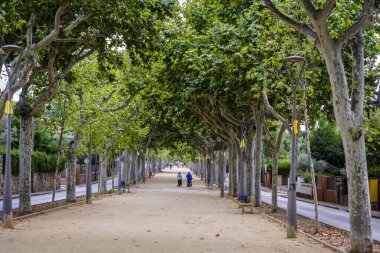 LA GARRIGA, İspanya - 8 Eylül 2019: El Passeig de La Garriga boyunca yürüyen insanlar, motorlu araçlar için yasaklanmış bir yaya caddesi.