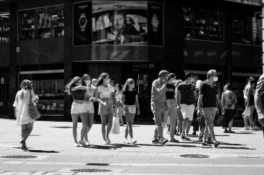 PONTEVEDRA, SPAIN - 24 Temmuz 2020: Sıcak bir yaz gününde şehir merkezinde, COVID-19 salgını sırasında maske takarak yürüyen insanlarla birlikte.