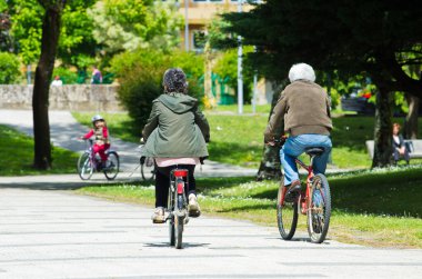 PONTEVEDRA, İSPA - 25 Mayıs 2014: Bir erkek ve bir kadın şehir parkı için bisiklet sürüyorlar.