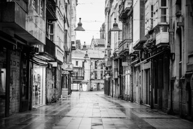 PONTEVEDRA, İspanya - 21 Şubat 2021: COVID-19 salgını sırasında tarihi merkezin sokakları neredeyse terk edilmiş, yağmurlu bir günün ardından ıslanmış.