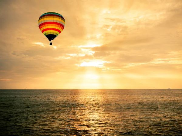 Heißluftballon über dem Meer bei Sonnenuntergang — Stockfoto