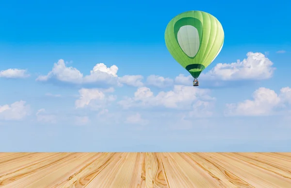 Houten vloer en hete lucht ballon op blauwe hemel — Stockfoto